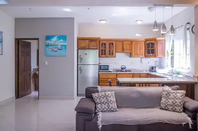 a living room with a couch and a kitchen at Zula Inn Aparthotel in Santa Teresa Beach