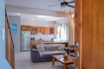 a living room with a couch and a kitchen at Zula Inn Aparthotel in Santa Teresa Beach
