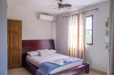 a bedroom with a bed with two towels on it at Zula Inn Aparthotel in Santa Teresa Beach