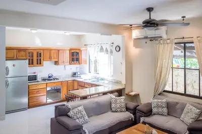 a living room with a couch and a kitchen at Zula Inn Aparthotel in Santa Teresa Beach