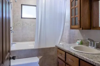 a bathroom with a sink and a tub and a toilet at Zula Inn Aparthotel in Santa Teresa Beach