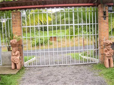a gate with two statues sitting in front of it at Casa Sophia 3 listings Apartment 1 or Apartment 2 separately or Apt 1 and 2 together all with FO internet in Guápiles