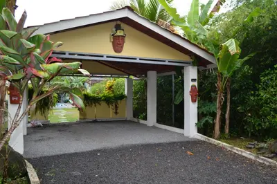 a yellow and white garage with a driveway at Casa Sophia 3 listings Apartment 1 or Apartment 2 separately or Apt 1 and 2 together all with FO internet in Guápiles