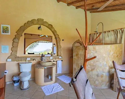 a bathroom with a sink and a toilet and a mirror at Villa Mango B&B in Nosara