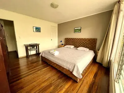 a bedroom with a bed and a wooden floor at Costa Rica Guesthouse in San José
