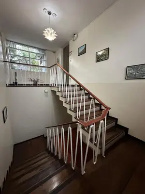 a wooden staircase in a house with a window at Costa Rica Guesthouse in San José