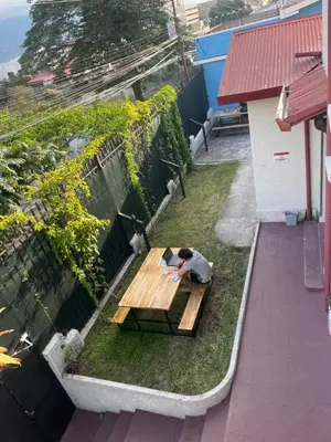 a man sitting on a picnic table in the grass at Costa Rica Guesthouse in San José