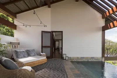 an outdoor patio with a couch and a pool at Four Seasons Resort Peninsula Papagayo, Costa Rica in Papagayo, Guanacaste