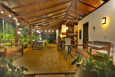 a living room with a wooden ceiling and tables and chairs at Lodge Margouillat in Tambor