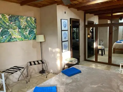a bedroom with a bed and a room with a window at Lodge Margouillat in Tambor