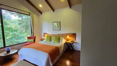 a bedroom with a bed and a large window at Monteverde Casa Mia, near main attractions and town! in Monteverde Costa Rica