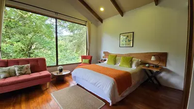 a bedroom with a bed and a large window at Monteverde Casa Mia, near main attractions and town! in Monteverde Costa Rica