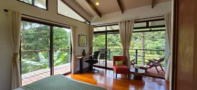 a bedroom with a large glass door with a balcony at Monteverde Casa Mia, near main attractions and town! in Monteverde Costa Rica