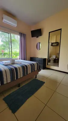 a bedroom with a bed and a large mirror at Hotel Campestre Arenal in Fortuna