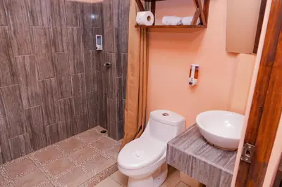 a bathroom with a toilet and a sink and a shower at Hotel Campestre Arenal in Fortuna
