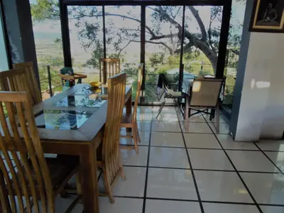 a dining room with a glass table and chairs at Salamandra Room in Escazu