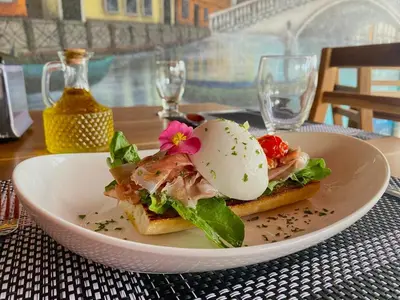 a white plate with a sandwich on a table at Hotel Vista del Cerro in Fortuna