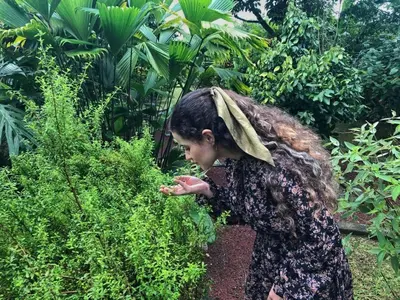 a young girl is looking at a bush at Hotel Vista del Cerro in Fortuna