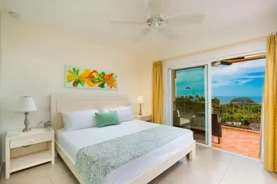 a bedroom with a bed and a view of the ocean at Jardin del Eden Boutique Hotel in Tamarindo