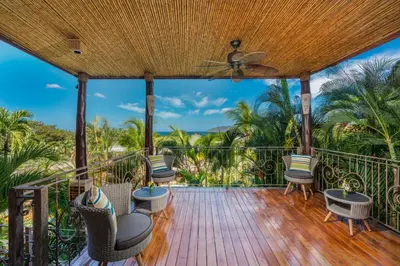 a deck with chairs and a ceiling fan at Jardin del Eden Boutique Hotel in Tamarindo