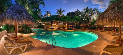 a swimming pool with chairs and umbrellas at Jardin del Eden Boutique Hotel in Tamarindo