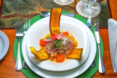 a white plate with food on a table at Jardin del Eden Boutique Hotel in Tamarindo