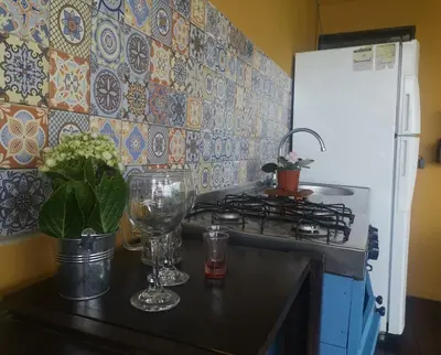 a kitchen with a stove and a counter with a wine glass at Dreamcatcher house in Sarchí