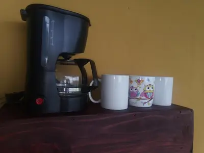 two coffee cups sitting on a counter next to a coffee maker at Dreamcatcher house in Sarchí