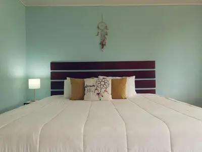 a bedroom with a large white bed with pillows at Dreamcatcher house in Sarchí
