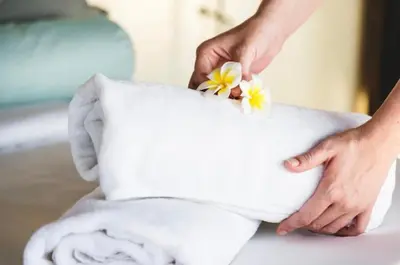 a person putting flowers on top of a towel at Calipso Ocean Lodge- Avellana Beach Hotel in Playa Avellana
