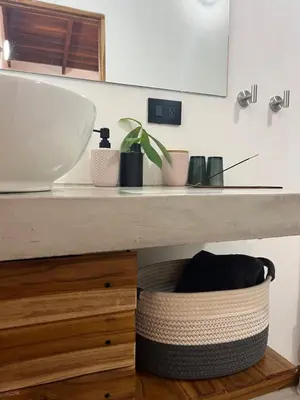a bathroom counter with a sink and a basket under it at Calipso Ocean Lodge- Avellana Beach Hotel in Playa Avellana