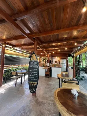 a restaurant with tables and a surfboard in the middle at Calipso Ocean Lodge- Avellana Beach Hotel in Playa Avellana