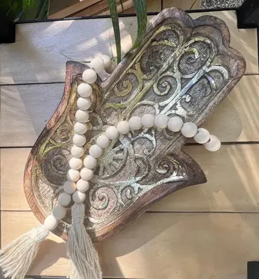 a wooden feather with pearl beads on a table at Calipso Ocean Lodge- Avellana Beach Hotel in Playa Avellana