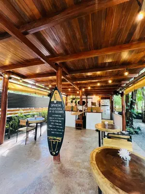a building with tables and a surfboard in the middle at Calipso Ocean Lodge- Avellana Beach Hotel in Playa Avellana