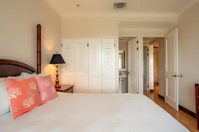 a bedroom with a white bed with a pink pillow at Elegant 3BR Condo - Bougainvillea - Reserva Conchal Golf Resort in Playa Conchal