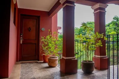 a front door of a house with potted plants at Elegant 3BR Condo - Bougainvillea - Reserva Conchal Golf Resort in Playa Conchal