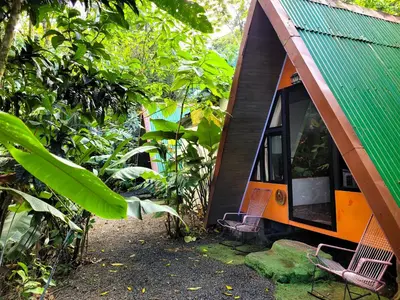 a small house with two chairs in front of it at Chalets Silencio del Bosque in Fortuna