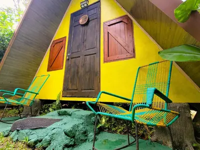two chairs in front of a house with a door at Chalets Silencio del Bosque in Fortuna