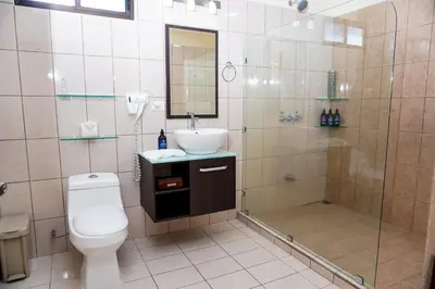 a bathroom with a shower and a toilet and a sink at Sibu Boutique Hotel in Monteverde Costa Rica