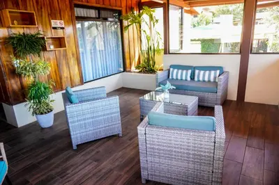 a porch with wicker chairs and tables and plants at Sibu Boutique Hotel in Monteverde Costa Rica