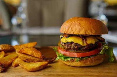 a hamburger and french fries on a cutting board at Sibu Boutique Hotel in Monteverde Costa Rica