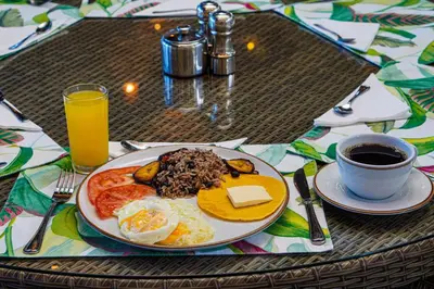 a plate of breakfast food on a table with a cup of coffee at Sibu Boutique Hotel in Monteverde Costa Rica