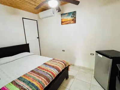 a bedroom with a bed with a colorful blanket on it at Lovely rental unit in Nosara- steps from the beach in Nosara