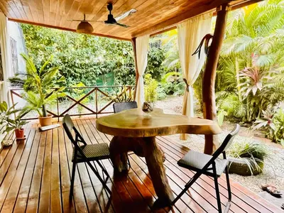 a wooden deck with a table and chairs on it at Lovely rental unit in Nosara- steps from the beach in Nosara