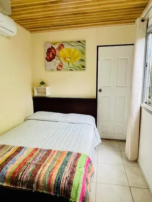 a bedroom with a bed with a colorful blanket at Lovely rental unit in Nosara- steps from the beach in Nosara