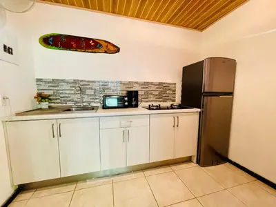 a kitchen with a sink and a refrigerator at Lovely rental unit in Nosara- steps from the beach in Nosara