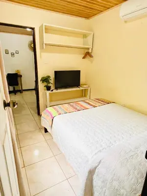 a bedroom with a bed and a flat screen tv at Lovely rental unit in Nosara- steps from the beach in Nosara