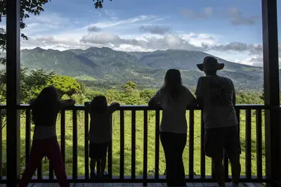 a group of people standing on a balcony looking out at the mountains at 