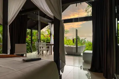a bedroom with a tub and a bed with a view at Oxygen Jungle Villas & Spa in Uvita