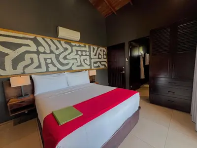 a bedroom with a large bed with a red blanket at Oxygen Jungle Villas & Spa in Uvita